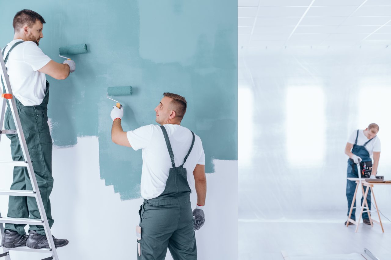 men painting empty home interior e1698227366132